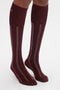 Person wearing Victoria Beckham Superfine Rib Socks In Burgundy, standing on a white background.