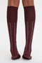 Back view of a person wearing Victoria Beckham Superfine Rib Socks In Burgundy with vertical white stripes made from 100% cotton.