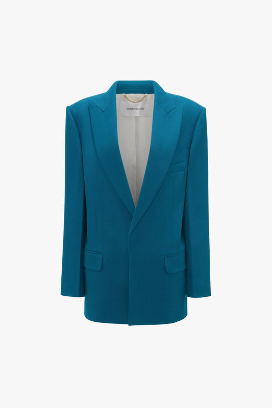A Victoria Beckham Peak Lapel Jacket In Petroleum with notched lapels, structured shoulders, two front flap pockets, and a single chest pocket, displayed on a plain white background.