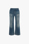 Blue flared jeans with a Victoria Beckham Cropped Kick Jean In Indigrey Wash effect and visible seams, isolated on a white background.