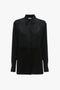 A timeless black, long-sleeve button-up shirt with a traditional collar and a square flap detail on the front, exuding modern femininity, the Contrast Bib Shirt In Black by Victoria Beckham.