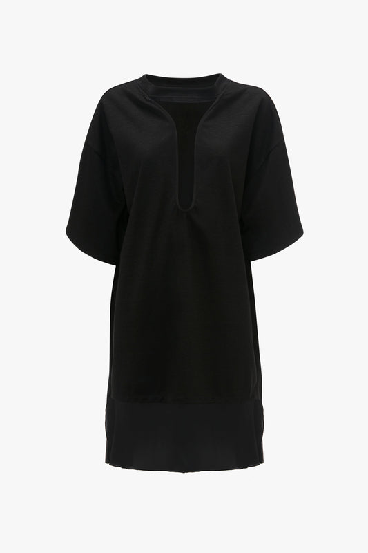 A black, deconstructed Frame Cut-Out T-Shirt Dress In Black with a deep V-neck and knee-length hem by Victoria Beckham, reminiscent of SS24 runway trends, displayed on a plain white background.
