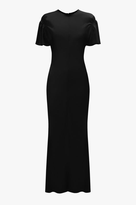 A full-length, short-sleeve black dress with a fitted silhouette, featuring a high neckline and a back zipper closure. This sophisticated piece is crafted from crepe back satin with a matte finish for an elegant touch. This is the Gathered Sleeve Midi Dress In Black by Victoria Beckham.