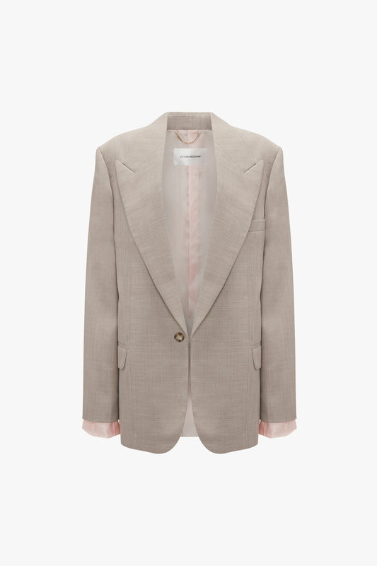 A Victoria Beckham Darted Sleeve Tailored Jacket In Sesame in pure wool with a single button closure, partially lined in pink satin, featuring a notched collar and long sleeves. Contemporary detailing elevates its modern appeal.