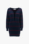 A dark blue, mid-weight knit Frame Detail Jumper Dress In Navy-Red by Victoria Beckham with red horizontal stripes and a deep directional curved neckline.