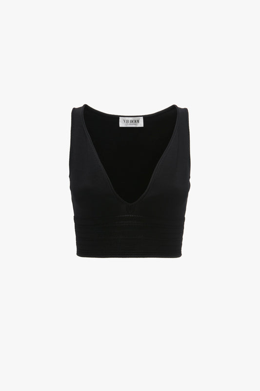 Black Frame Detail Sleeveless Top In Black by Victoria Beckham with a deep V-neckline and a ribbed design below the bust, featuring contrasting stitch details for added flair. Body-sculpting fit ensures a flattering silhouette, all isolated on a white background.