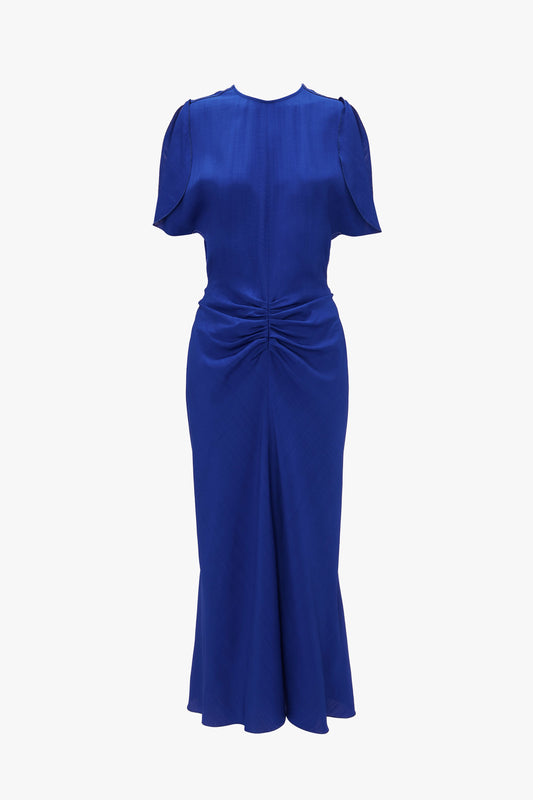 A Victoria Beckham palace blue, knee-length dress with cap sleeves, a gathered waist, and a twisted knot detail at the front, displayed against a white background.
