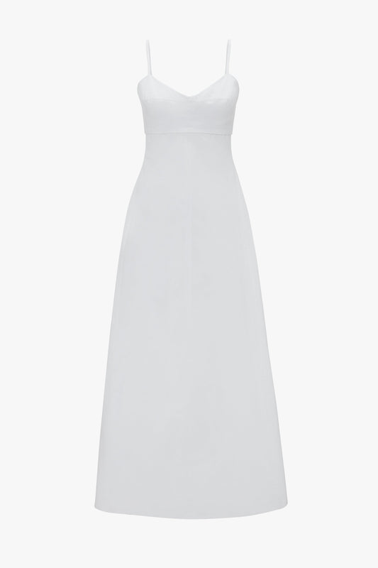A long, white sleeveless summer dress with adjustable thin shoulder straps and a fitted bodice. Made from breathable stretch cotton, the Cami Fit And Flare Midi In White by Victoria Beckham has a smooth, flowing silhouette.