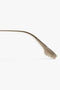 Side view of a thin, brown eyeglass temple arm with a series of ridged cutouts along its length, echoing a chic Victoria Beckham V Metal Pilot Sunglasses In Gold-Khaki design.