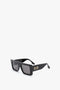 A pair of Victoria Beckham Oversized Frame Sunglasses In Black with dark lenses and a decorative metallic accent on the temples, reminiscent of the SS24 runway, placed on a plain white background.