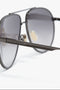 Close-up of Victoria Beckham V Metal Pilot Sunglasses In Grey Gradient with gunmetal grey gradient lenses and a metallic frame. The temple arm has the inscription "Victoria Beckham.