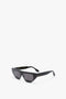 The Victoria Beckham SS24 collection features the Victoria Beckham Layered Lens Visor Sunglasses In Black with thick frames and dark lenses, expertly placed on a white background.