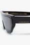 Close-up of Layered Lens Visor Sunglasses In Black from the Victoria Beckham eyewear SS24 collection, featuring a sophisticated layered lens visor and the name "Victoria Beckham" inscribed in gold on the arm.