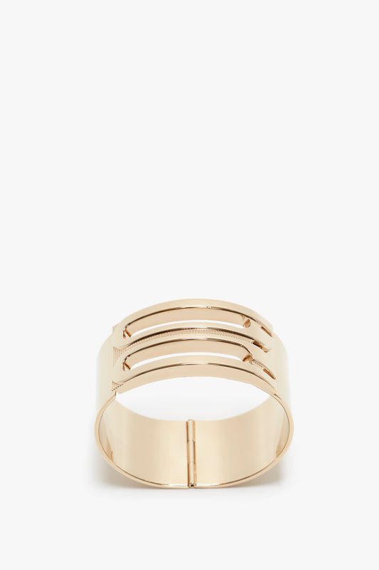 Gold-colored, structured frame bracelet featuring parallel rectangular cutouts and a hinge closure, crafted from gold-plated brass. This is the Exclusive Frame Bracelet In Gold by Victoria Beckham.