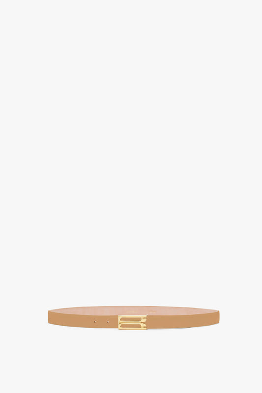 A Victoria Beckham Frame Belt In Camel Leather with a small, gold buckle centered on a plain white background.