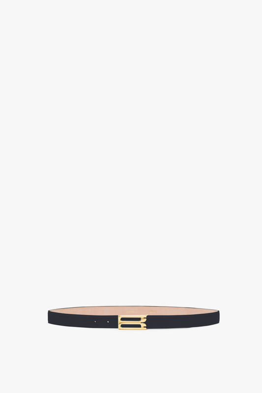 A slim Victoria Beckham Exclusive Frame Belt in Midnight Navy Leather with a small, gold rectangular buckle, displayed horizontally against a plain light background.