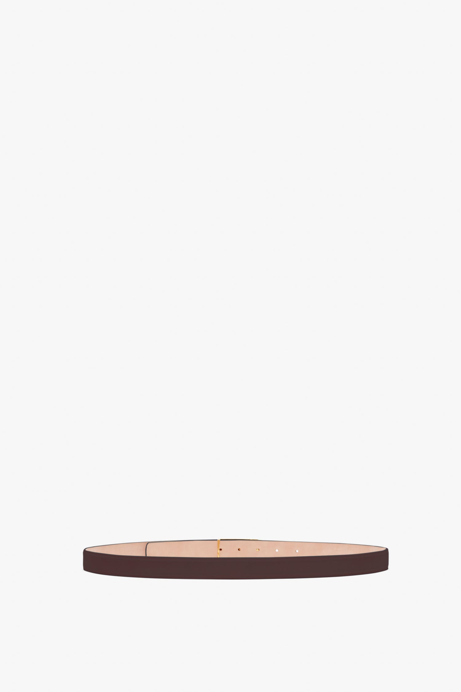 A thin, burgundy calf leather belt with a simple buckle and gold hardware, laid flat against a white background, the Frame Belt In Burgundy Leather by Victoria Beckham.