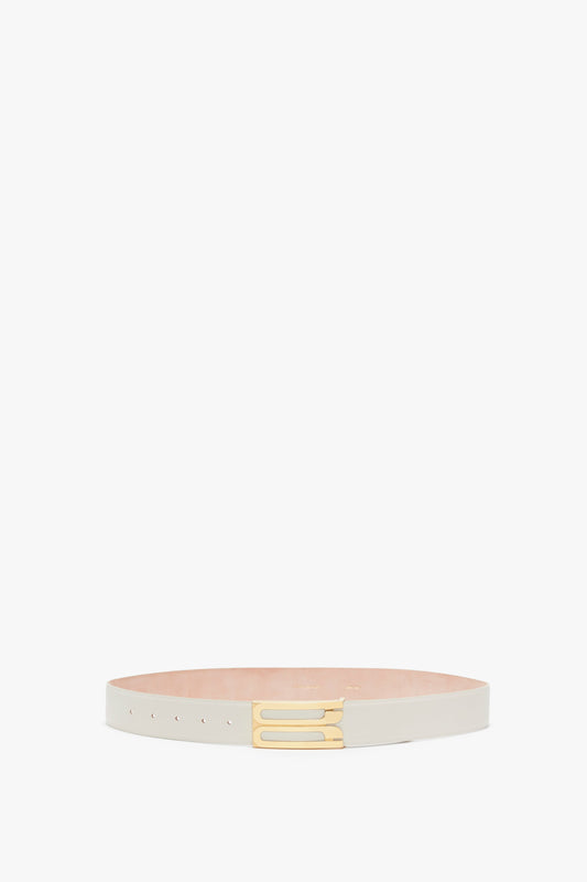 A Victoria Beckham Jumbo Frame Belt In Latte Leather, made of calf leather with a rectangular gold hardware buckle, placed on a white background.