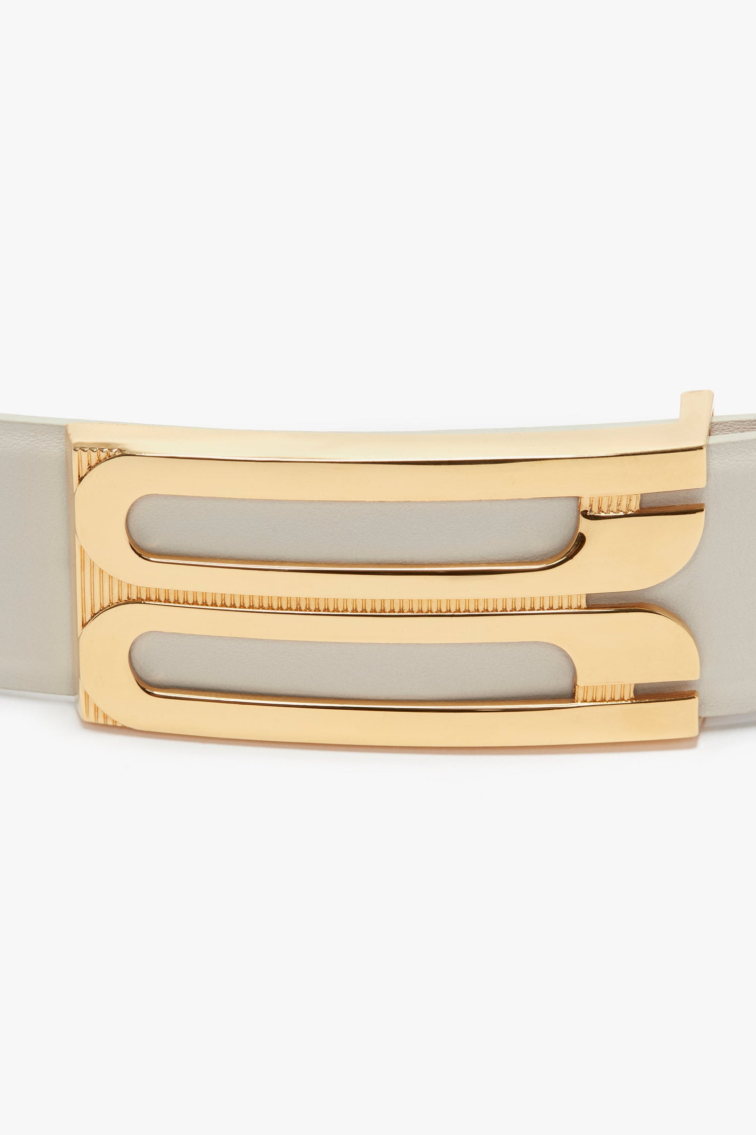 Close-up of a Victoria Beckham Jumbo Frame Belt In Latte Leather with gold hardware, featuring a geometric design on the buckle.