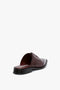 A rear view of a single, Flat Lace Up Mules In Bordeaux Leather by Victoria Beckham with brogue detailing and a low black heel crafted from luxurious calfskin leather against a white background.