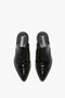 Top view of a pair of black leather Flat Lace Up Mules In Black Leather by Victoria Beckham with lace-up detailing and a designer label visible on the insoles, echoing the classic elegance seen in SS24 runway trends.