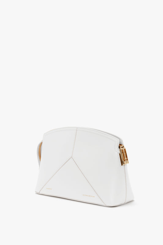 The Exclusive Victoria Clutch Bag In White Leather with geometric shaping, subtle stitch detailing, and thin gold hardware accents—an embodiment of the elegance and sophistication you’d expect from Victoria Beckham.