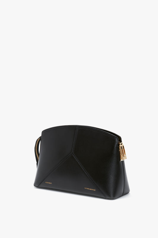 Victoria Clutch Bag In Black Leather by Victoria Beckham with gold accents and a structured silhouette, featuring a geometric design.