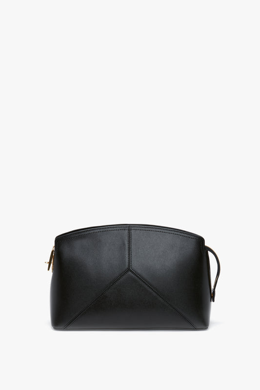 A Victoria Beckham Victoria Clutch Bag In Black Leather with a minimalist design, featuring a zip closure and a subtle stitched pattern on the front, enhanced by a structured silhouette.