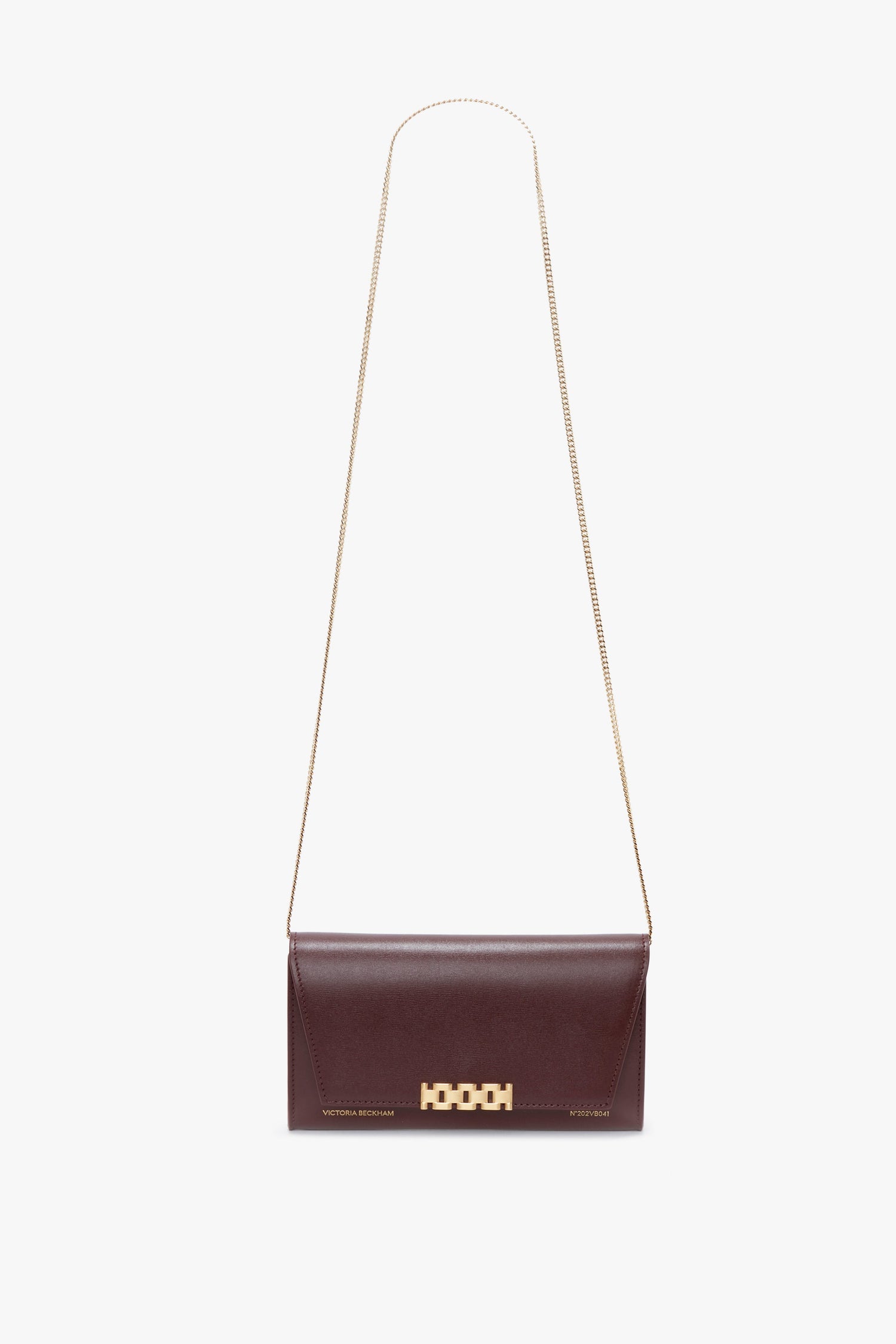 A Wallet On Chain In Burgundy Leather, crafted from luxurious palmellato leather, featuring a gold chain strap and a gold geometric clasp, isolated on a white background by Victoria Beckham.