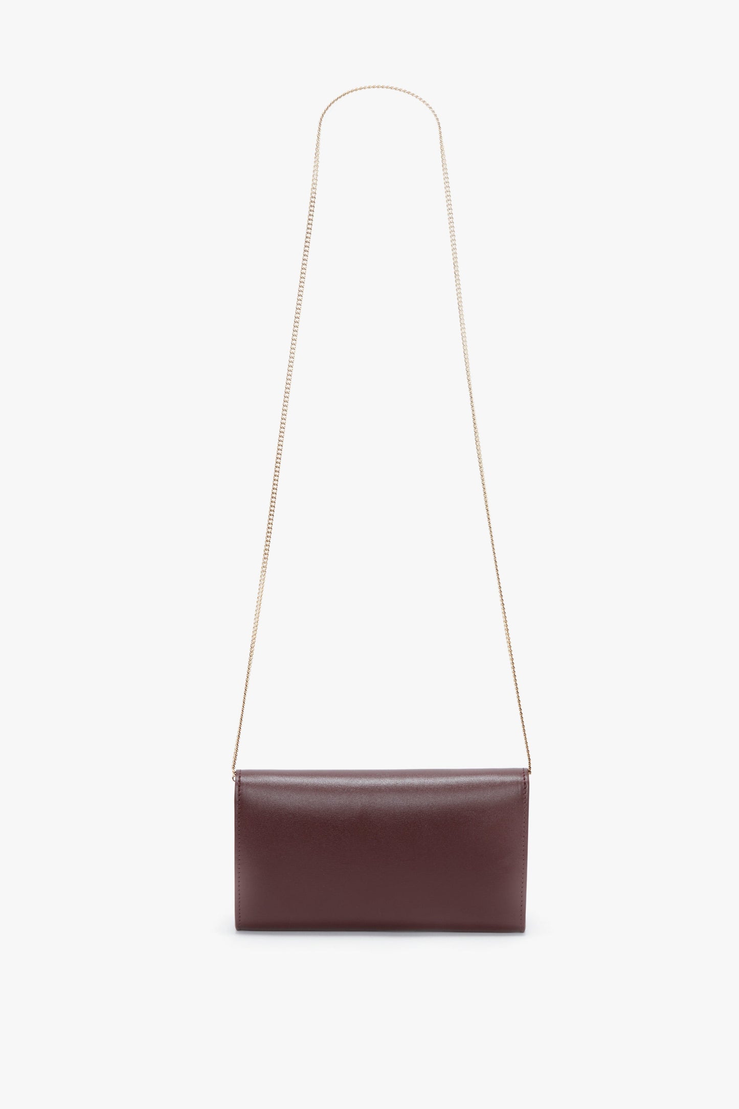 A Victoria Beckham Wallet On Chain In Burgundy Leather crafted from palmellato leather with a gold chain strap on a white background.