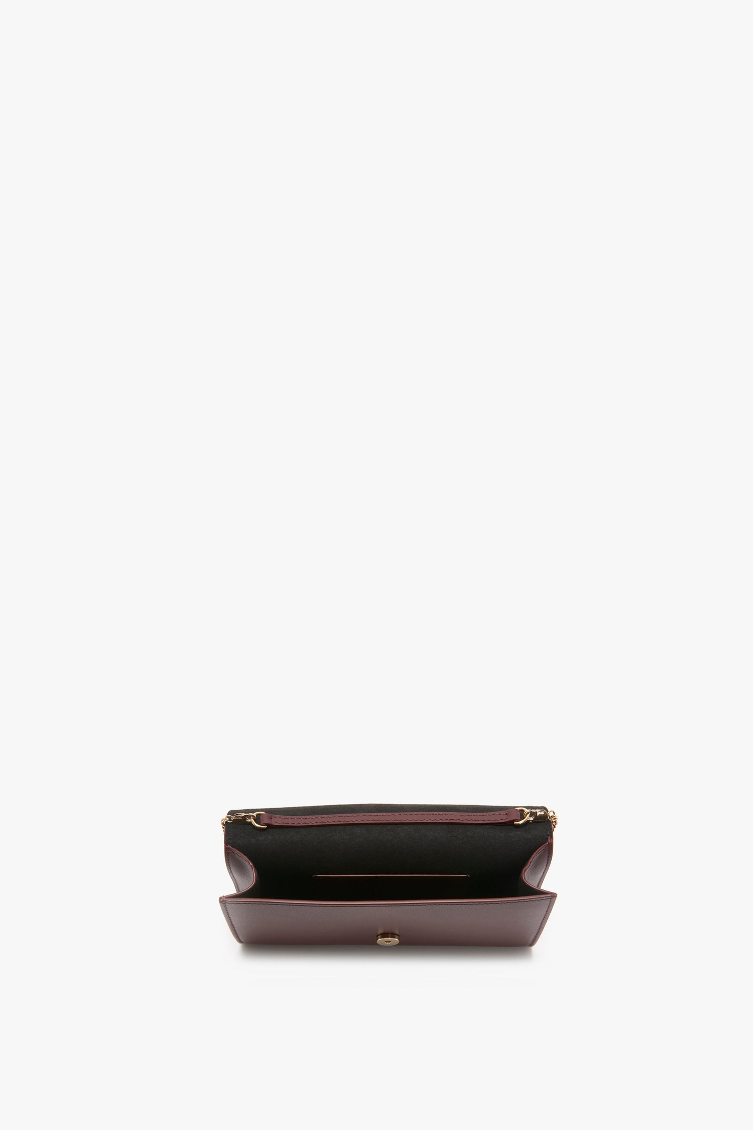 A medium-sized open wallet crafted from luxurious palmellato leather, featuring an empty interior with card slots and a zipper compartment. The Wallet On Chain In Burgundy Leather by Victoria Beckham design adds a touch of elegance, seamlessly blending style with functionality.