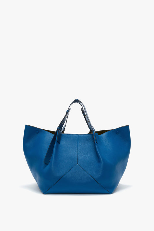 A Victoria Beckham W11 Medium Tote Bag In Vibrant Blue with a wide opening, double handles, and a sleek, minimalist design crafted from grained leather.