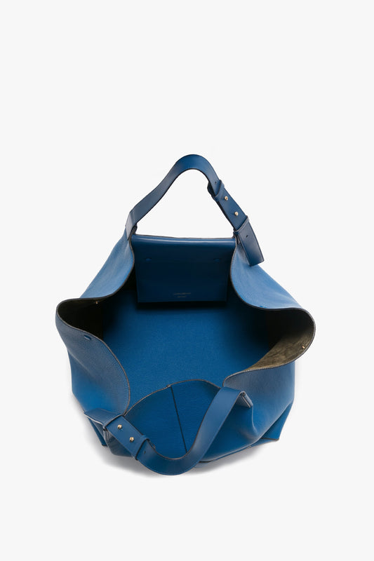 Victoria Beckham's W11 Medium Tote Bag In Vibrant Blue features vibrant blue grained leather with an open top showing the spacious interior and two shoulder straps; a small internal pocket is visible.