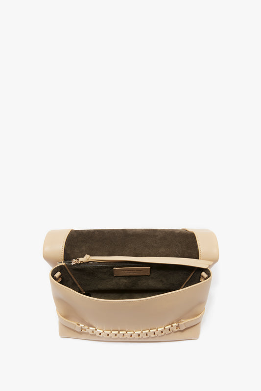 Open Victoria Beckham beige crossbody bag with a black interior and a visible zipper compartment, shown against a white background.
