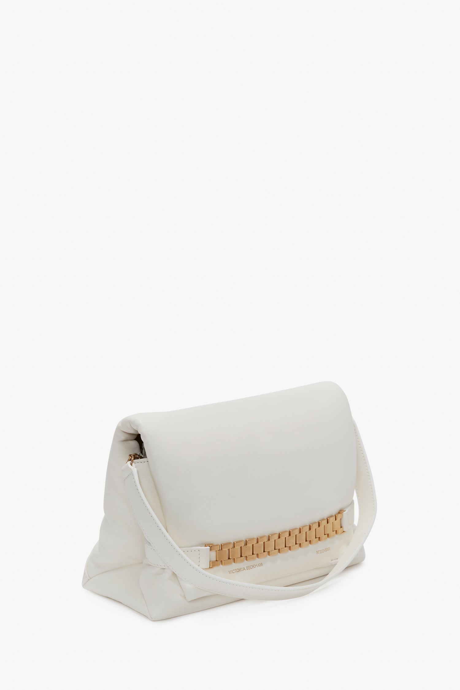 A white Victoria Beckham Puffy Chain Pouch Bag With Strap In White Leather with a fold-over design and a woven beige accent near the bottom. It features a single white strap and a minimalist appearance, with an optional detachable shoulder strap for added versatility.