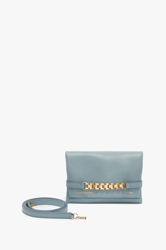 Light blue Mini Chain Pouch Bag With Long Strap In Ice Leather by Victoria Beckham with a gold-tone chain detail and matching detachable strap, displayed against a white background.