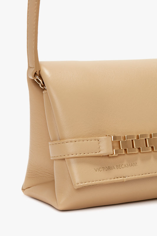 Cream-colored leather crossbody shoulder bag with gold chain detail and "Victoria Beckham" branding on the front.