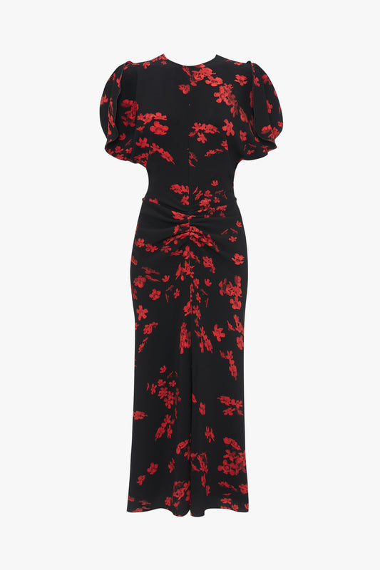 A Gathered Waist Midi Dress In Sci-Fi Black Floral with red floral patterns, featuring short puffed sleeves, a fitted waist with ruching, and a flared skirt for a flattering fit-and-flare silhouette from Victoria Beckham.