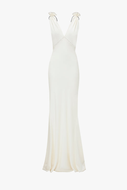 An Victoria Beckham Gathered Shoulder Floor-Length Cami Gown In Ivory crafted from luxurious crepe back satin, this floor-length, sleeveless ivory gown features a deep V-neckline and slight flare at the hem, displayed against a white background.