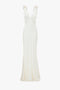 An Victoria Beckham Gathered Shoulder Floor-Length Cami Gown In Ivory crafted from luxurious crepe back satin, this floor-length, sleeveless ivory gown features a deep V-neckline and slight flare at the hem, displayed against a white background.