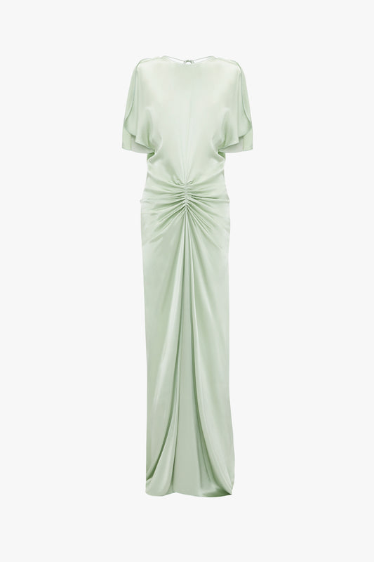 Exclusive Victoria Beckham floor-length gathered dress in jade with short sleeves, a draped front, and knot detail, displayed against a white background. This elegant gown also features an open back.