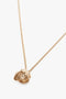 Victoria Beckham Exclusive Camellia Flower Necklace In Gold featuring a textured flower-shaped pendant on a fine chain, crafted in gold brushed brass and handcrafted in Italy, displayed on a plain white background.