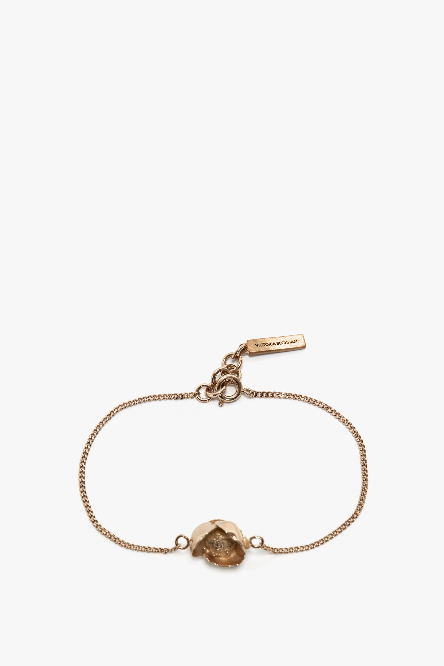 A delicate gold bracelet with a central stone and a small tag bearing the inscription "Victoria Beckham," featuring an adjustable chain for the perfect fit, the Exclusive Camellia Flower Bracelet In Gold.