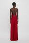 Person standing, facing away, wearing a 1990s-inspired, Low Back Cami Floor-Length Dress In Poppy Red by Victoria Beckham with thin straps and an open back design.