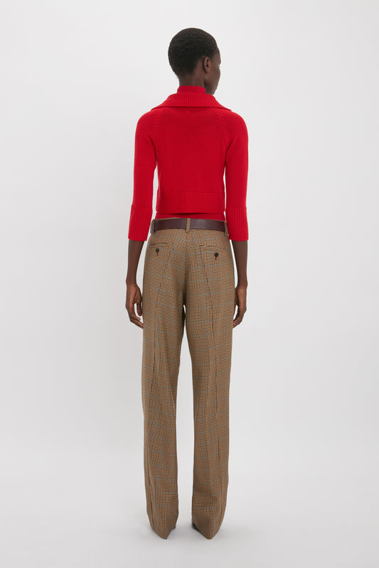 A person is standing with their back to the camera, wearing a Victoria Beckham Double Layer Top In Deep Red and brown checkered trousers.