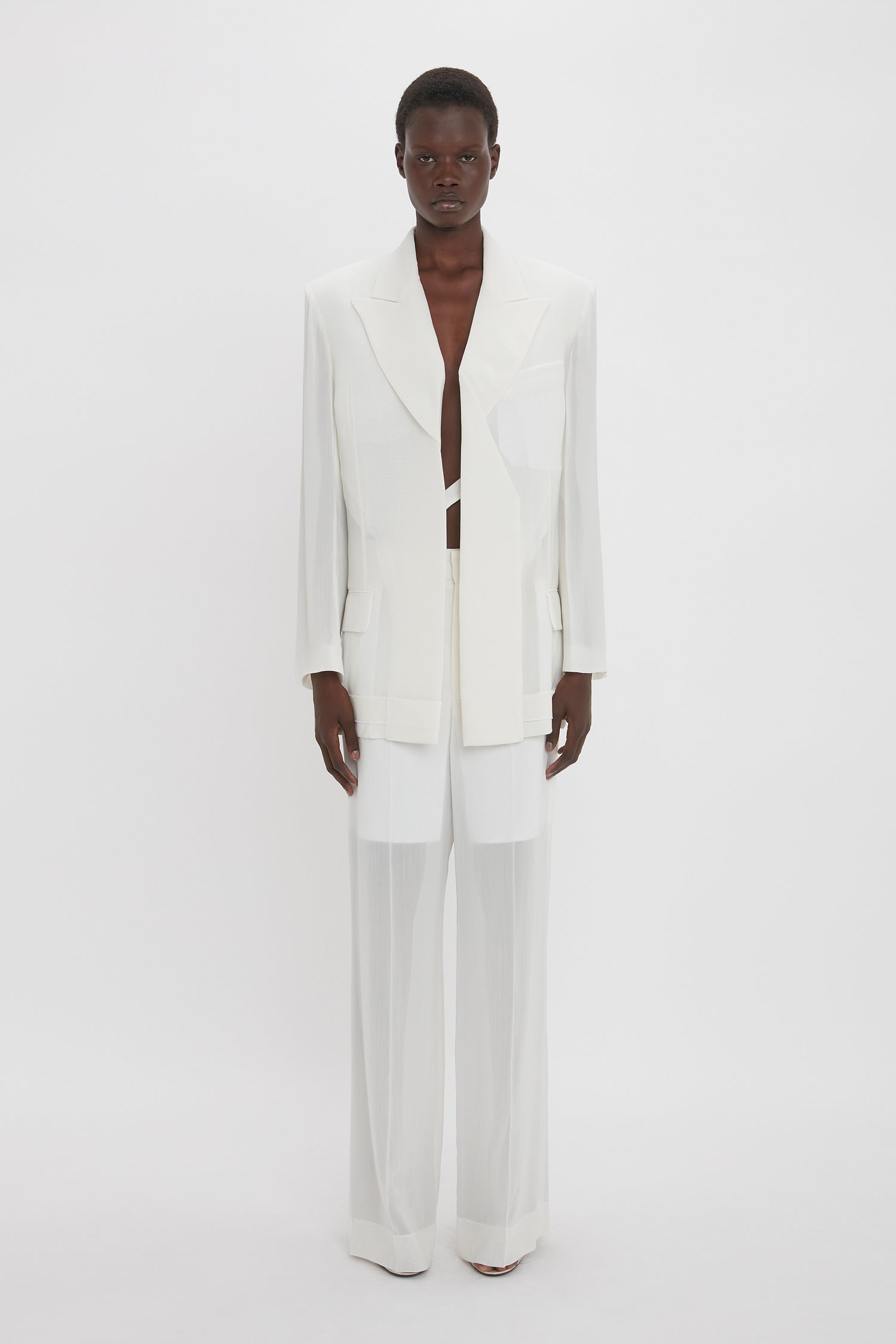 Person standing and facing forward, wearing a Victoria Beckham Fold Detail Tailored Jacket In White with matching pants made from featherweight wool against a plain white background.