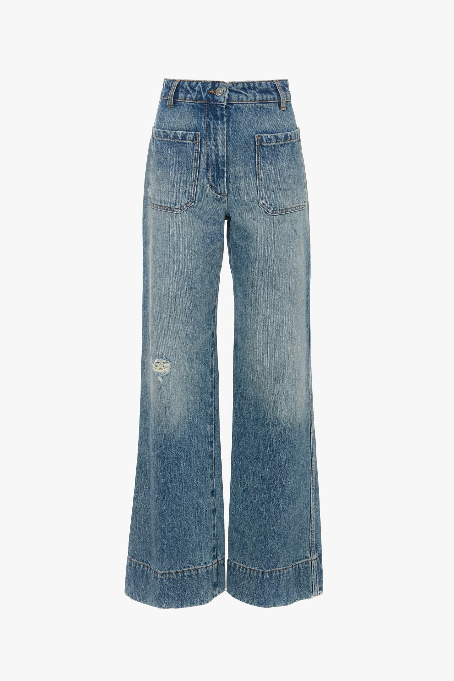 A pair of Alina High Waisted Jean In Worn Blue Wash Victoria Beckham jeans with seventies-inspired patch pockets and a small distressed section on the left knee.