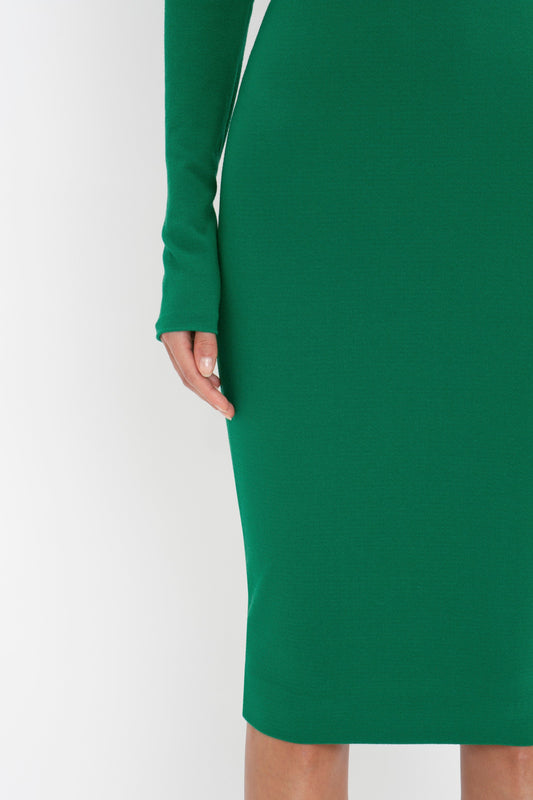 A person wearing a Victoria Beckham Long Sleeve T-Shirt Fitted Dress in Emerald with padded shoulders is shown from the mid-thigh down to just above the knee against a plain background.