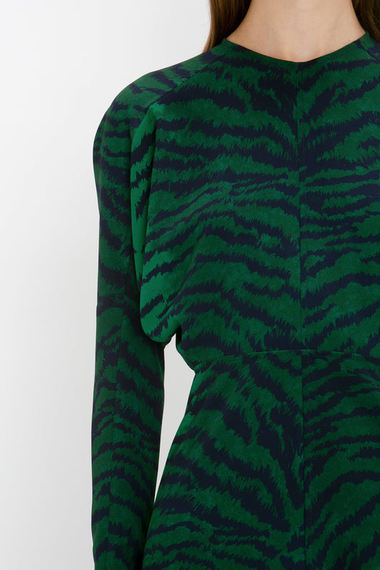 A close-up view of a woman's back, showing the upper section of a Dolman Midi Dress in Green-Navy Tiger Print by Victoria Beckham.