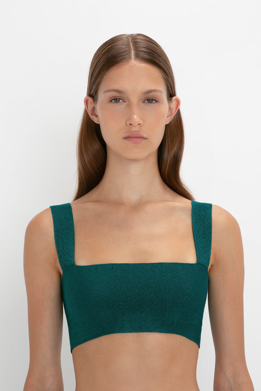 A person with long hair wears a green VB Body Strap Bandeau Top In Lurex Green and a stylish VB Body Flared Skirt, standing against a plain white background.